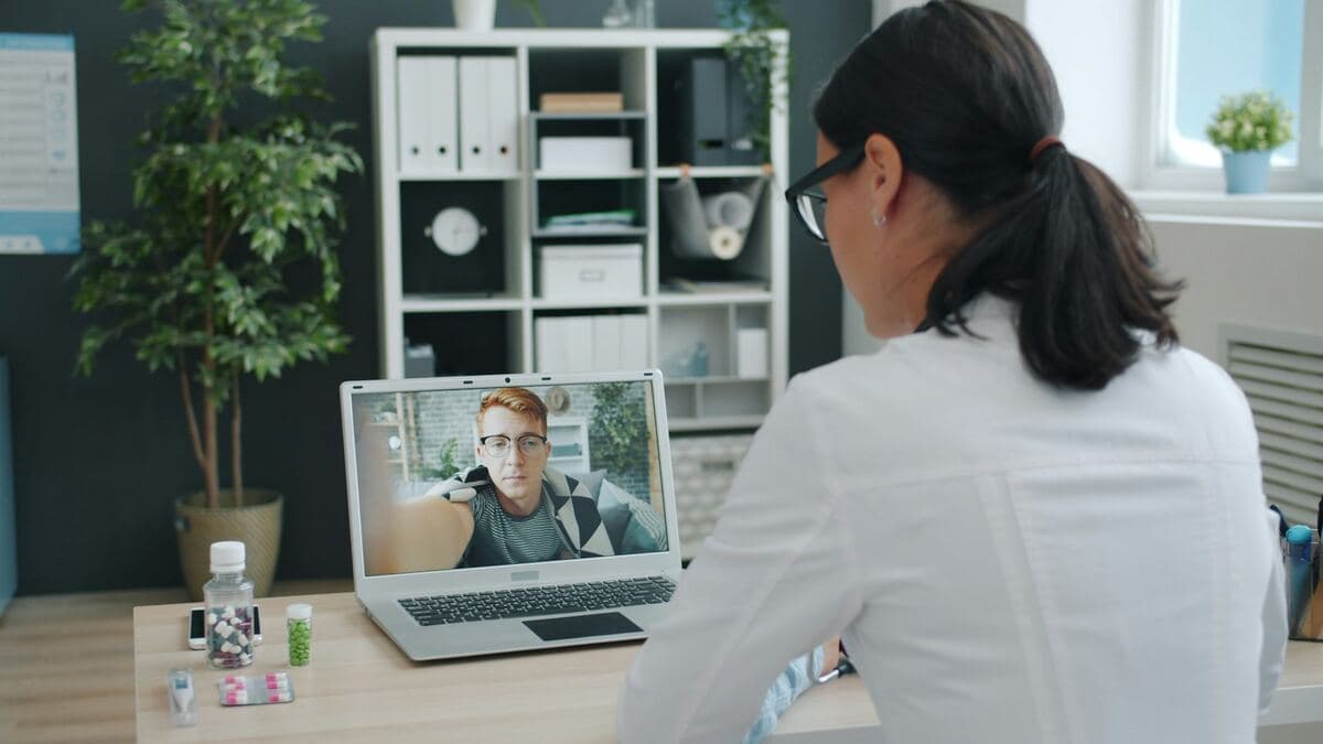 Doctor consulting a patient through a video call from a clinic office